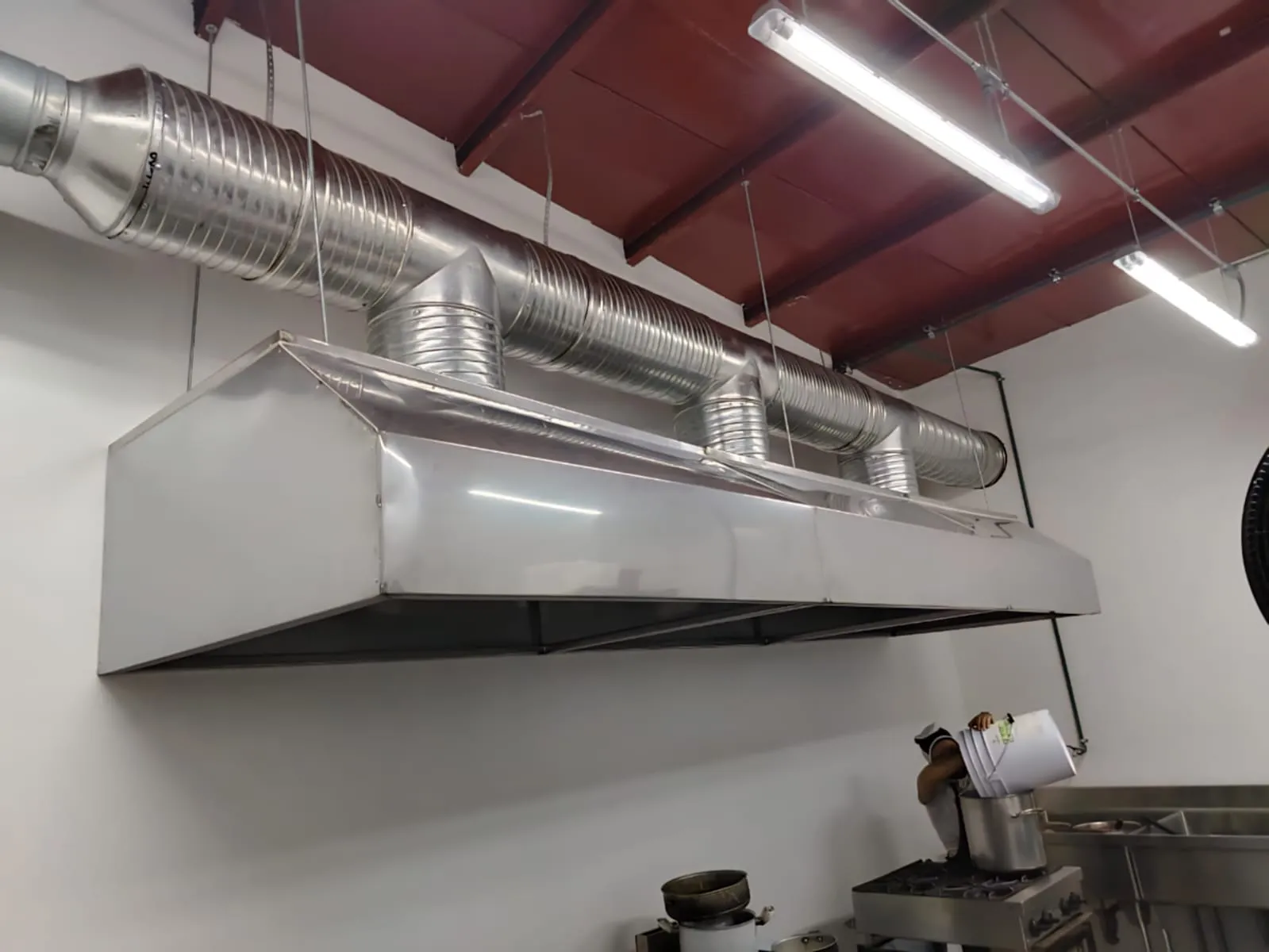 Campana de extracción de acero con ductos en una cocina comercial