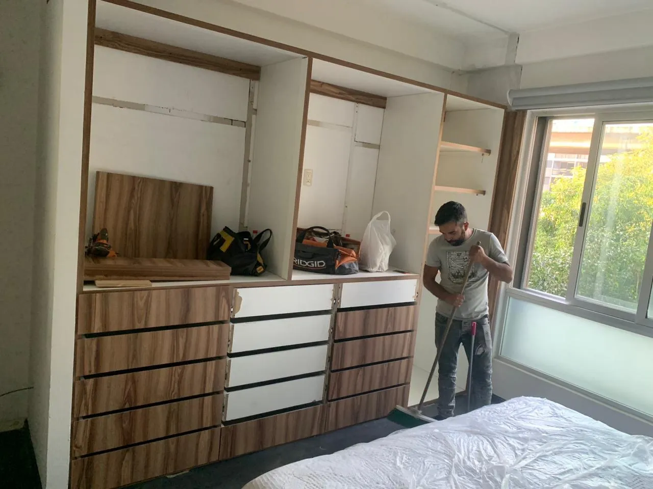 Instalación de closet de madera con cajones en recámara con vista al jardín