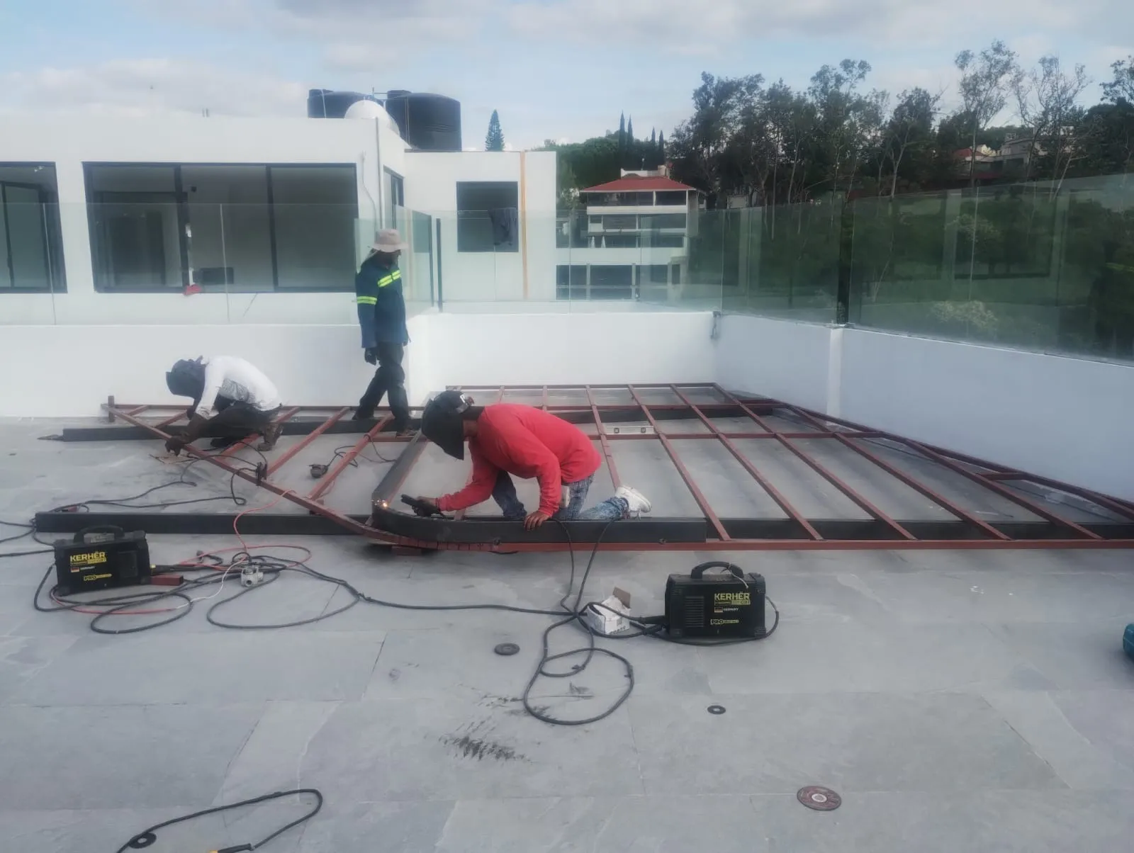 Soldadores armando bastidor metálico de deck para pérgola en roof garden
