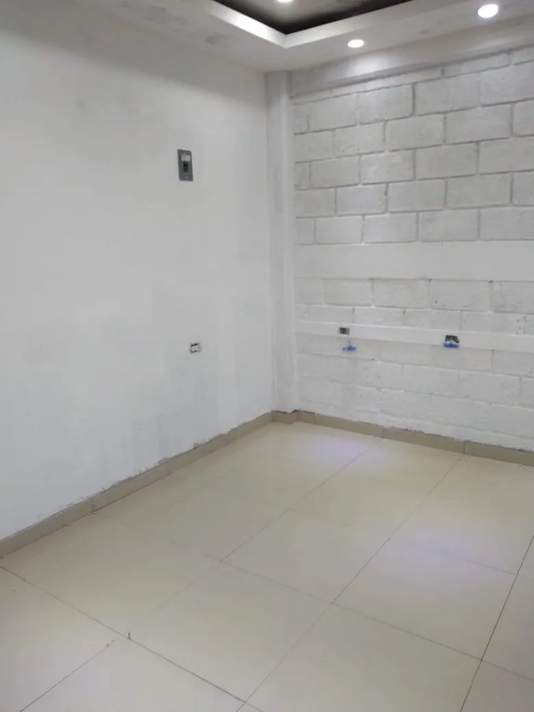 Interior remodelado con plafón, iluminación indirecta y muro de block pintado de blanco