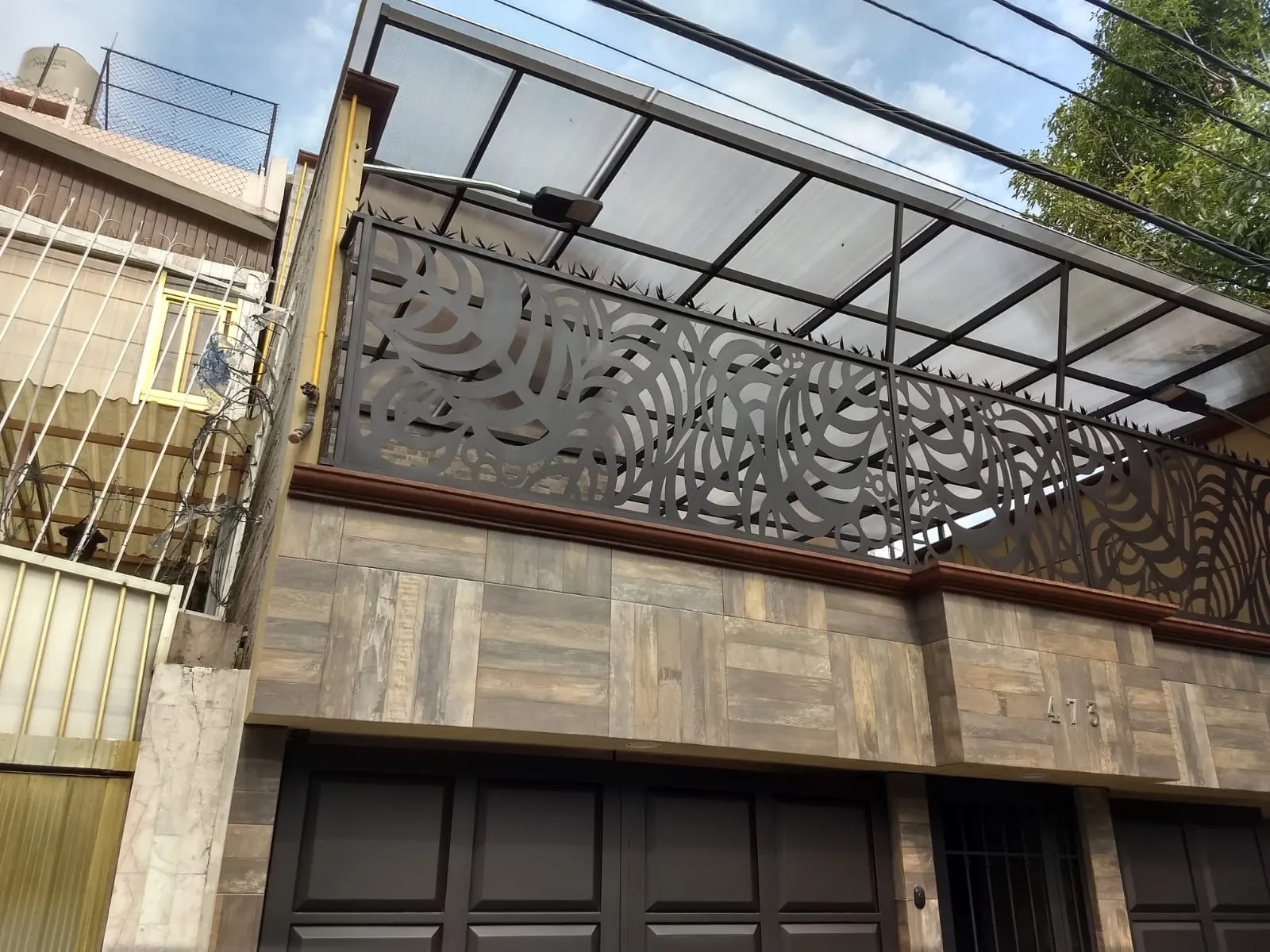 Techado de policarbonato en terraza con barandal de acero de corte artístico en fachada